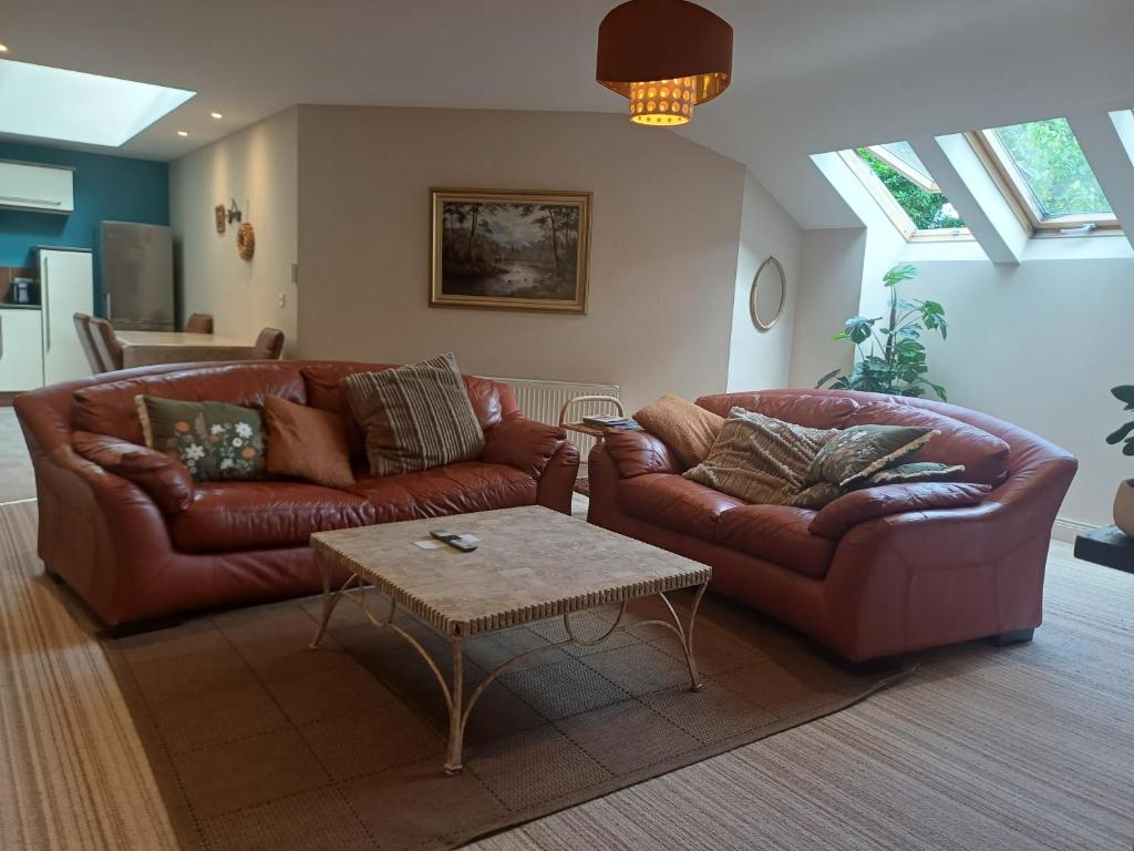a living room with two leather couches and a coffee table at Ethan House Holiday Suites in Killarney