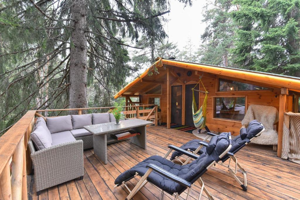 a deck with a couch and chairs on a cabin at Life House-Semkovo in Belitsa