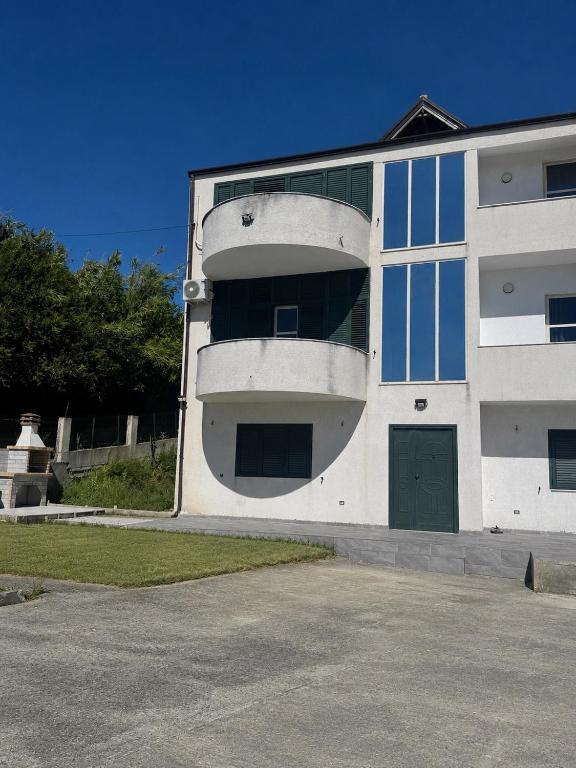 a large white building with a green door at Villa Cepeli in Golemasi