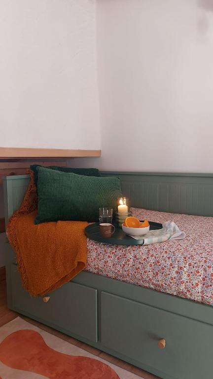 a bed with a table with a candle on it at Casa dos Malmequeres - Alegrete in Portalegre