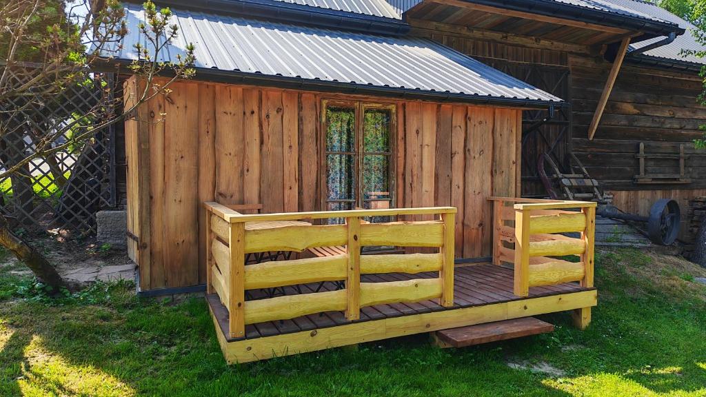 a large wooden cabin with a deck in the grass at Zaścianek Roztocze in Chłopków