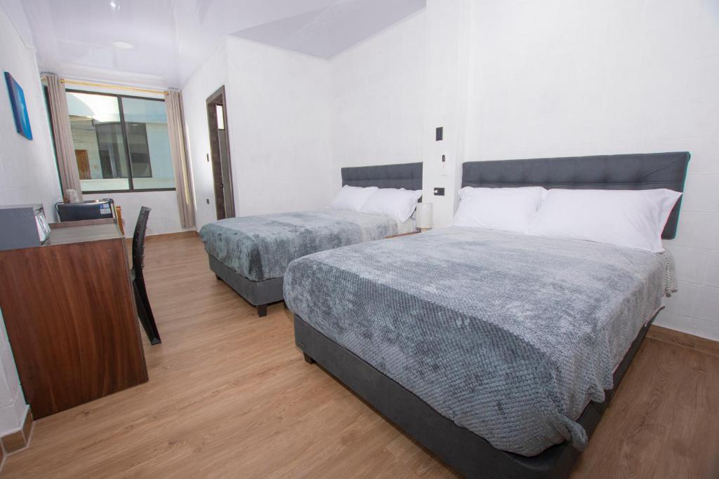 a hotel room with two beds and a television at Hospedaje Zerimar Hab 7 in Puerto Baquerizo Moreno