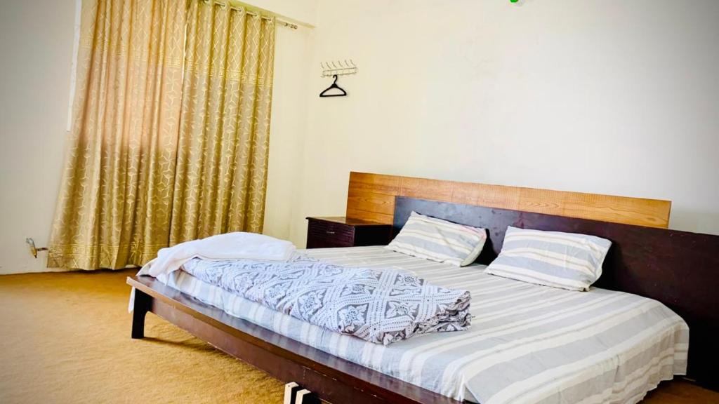a bedroom with a large bed with a wooden headboard at Murree Sky Heights in Khaira Gali