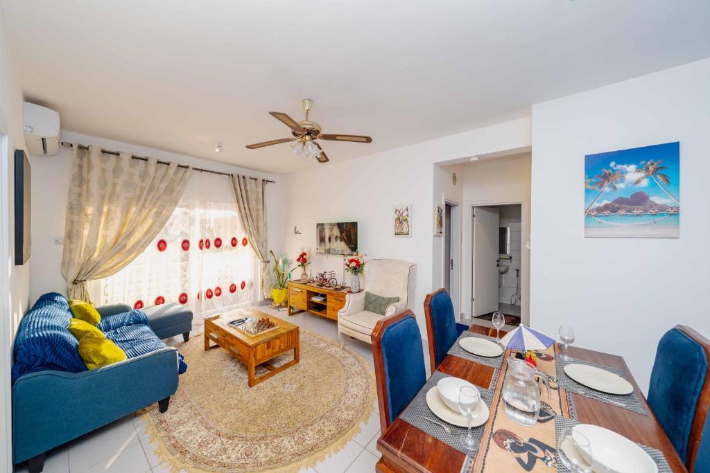a living room with a blue couch and a table at Zanzibar,Fumbatown 2 Bed Ocean view Apartment in Fumba