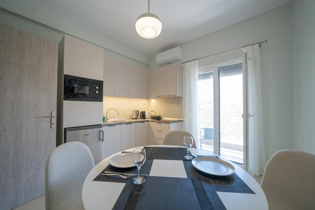 a dining room table with chairs and a kitchen at Gerania nature Residence 21 in Siátista