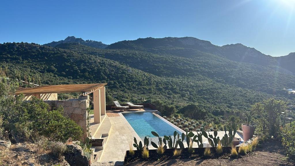 a swimming pool with a view of a mountain at Casa La Petite in San Pantaleo
