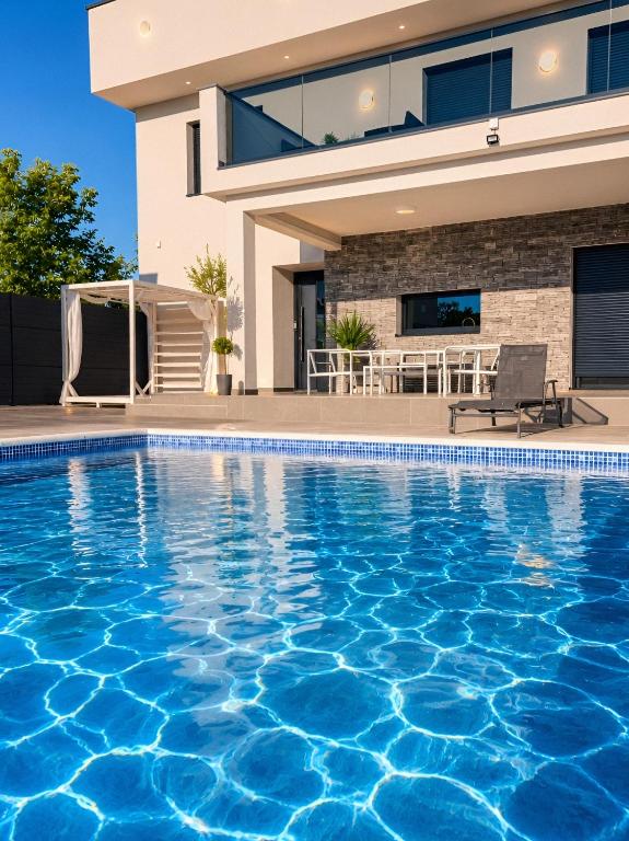 a swimming pool in front of a house at LUXIA PRIVATE ESTATE Sauna & Pool x Jacuzzi with Fireplace outdoor lounge in Bihać