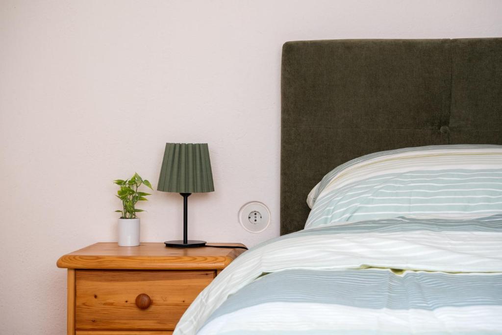 a bedroom with a bed and a lamp on a nightstand at Naturidyll Lavantall in Lading