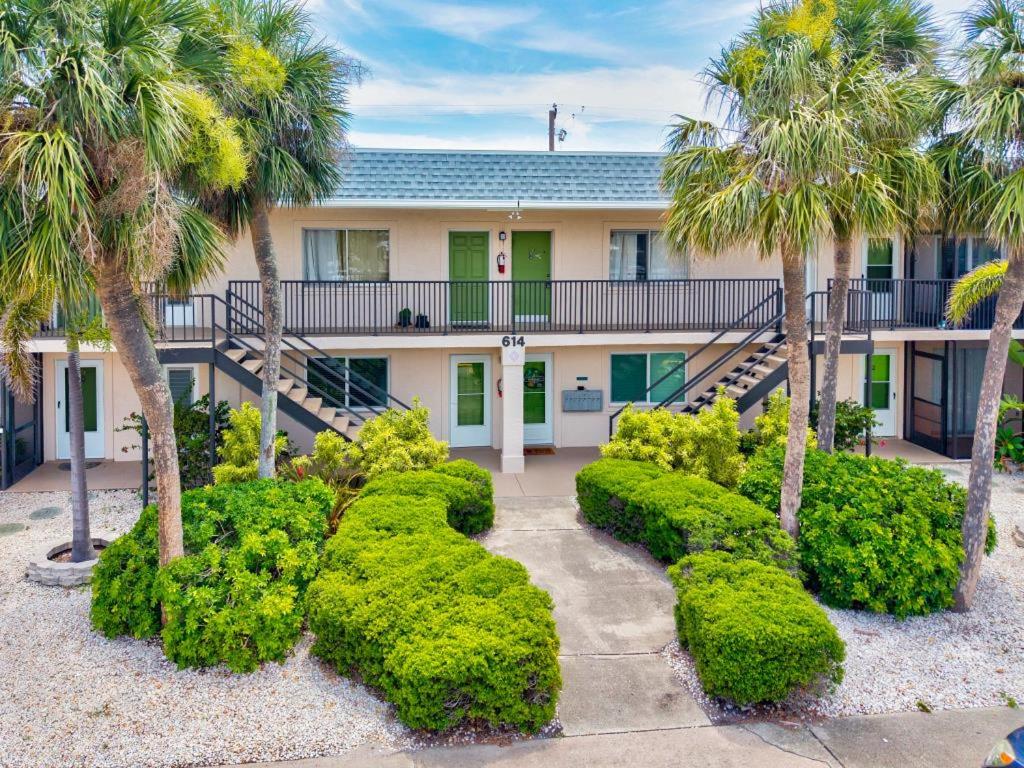 a house with palm trees and bushes in front of it at Shark tooth Condo in Venice