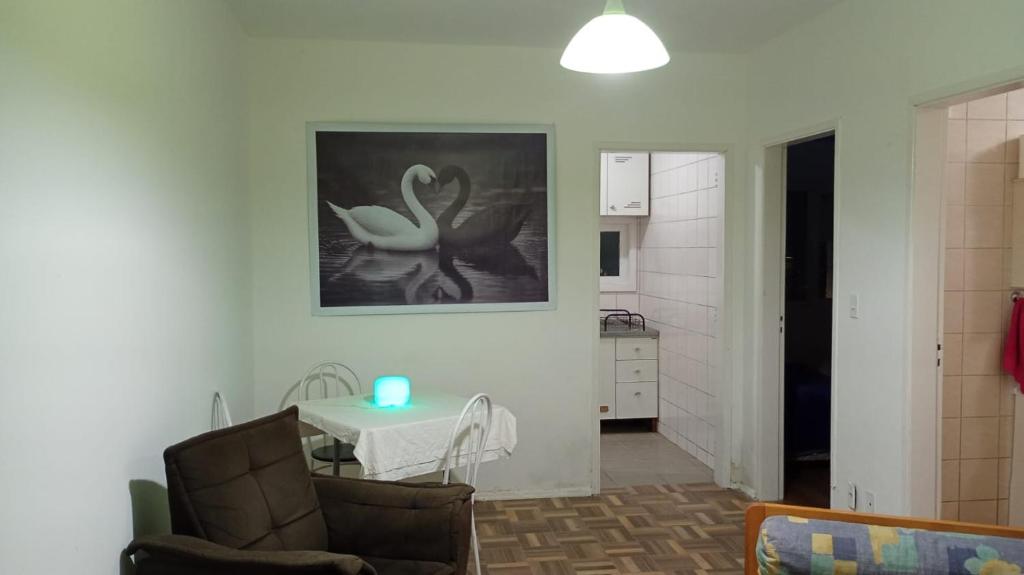 a living room with a table and a kitchen at Apartamento central bem localizado in Pelotas