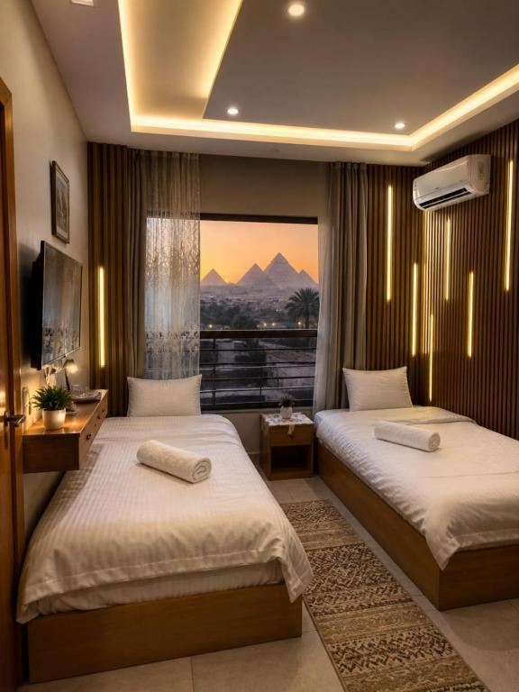 a hotel room with two beds and a window at Lava pyramids hotel in Cairo