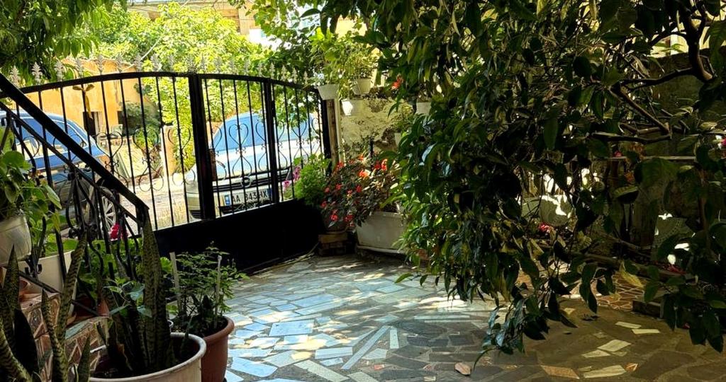 a garden with a gate and plants and a patio at Jazoj Family hotel in Orikum