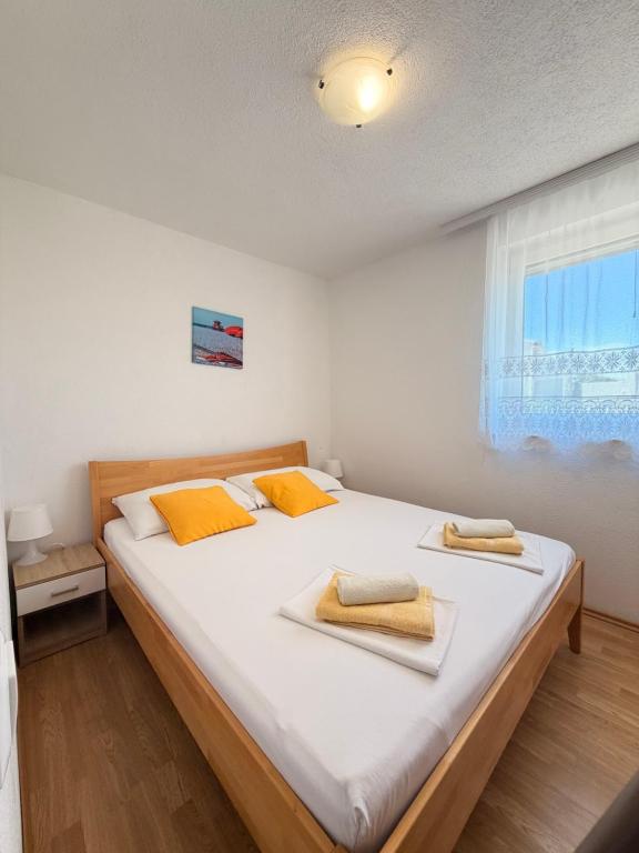 a bedroom with a large white bed with yellow pillows at Apartments TORO Pag in Pag