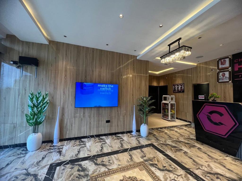 a lobby with a tv on a wooden wall at Charles Stainless Hotels in Abakaliki