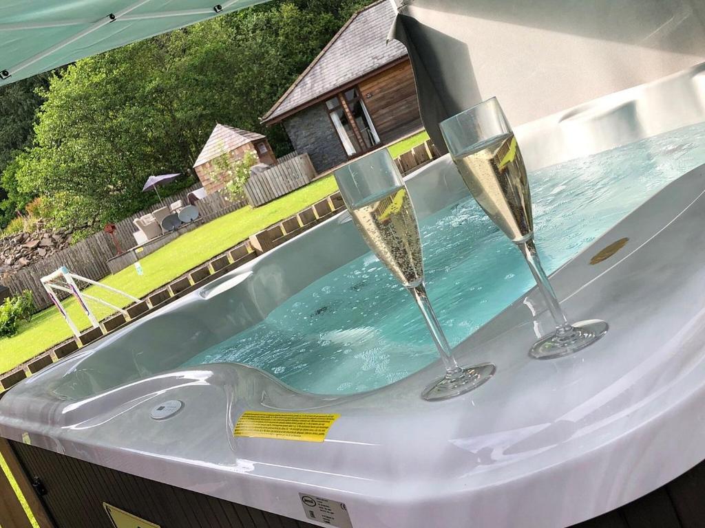 a bath tub with two wine glasses in it at Balmaha Lodges and Apartments in Balmaha
