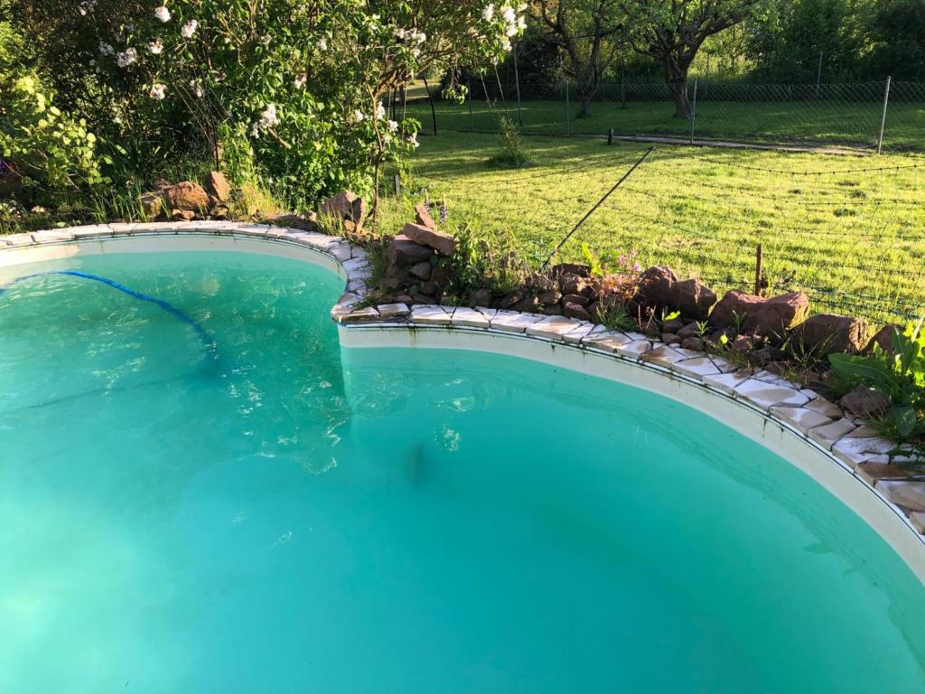 a swimming pool with blue water in a yard at Acorn Pool Tented Camp in Nidda