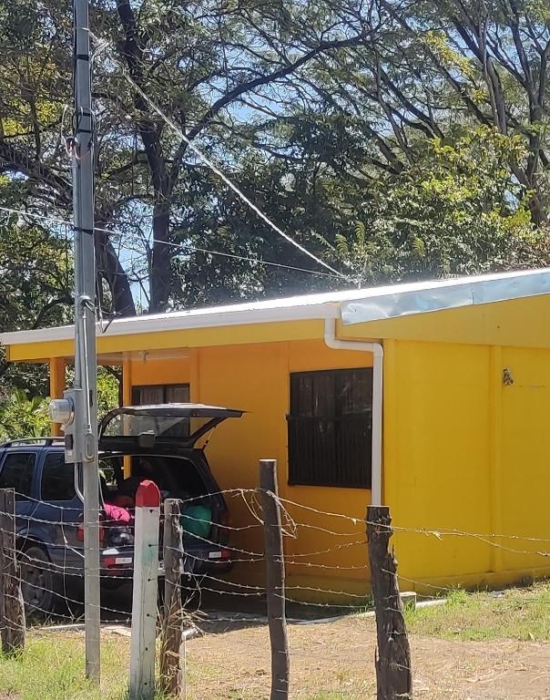 a car parked in front of a yellow trailer at Casa Amarilla in San Blas