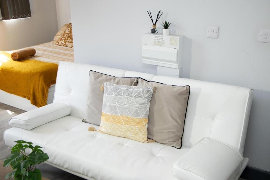a white couch with pillows in a living room at Stylish Studio in the Heart of Sheffield in Sheffield