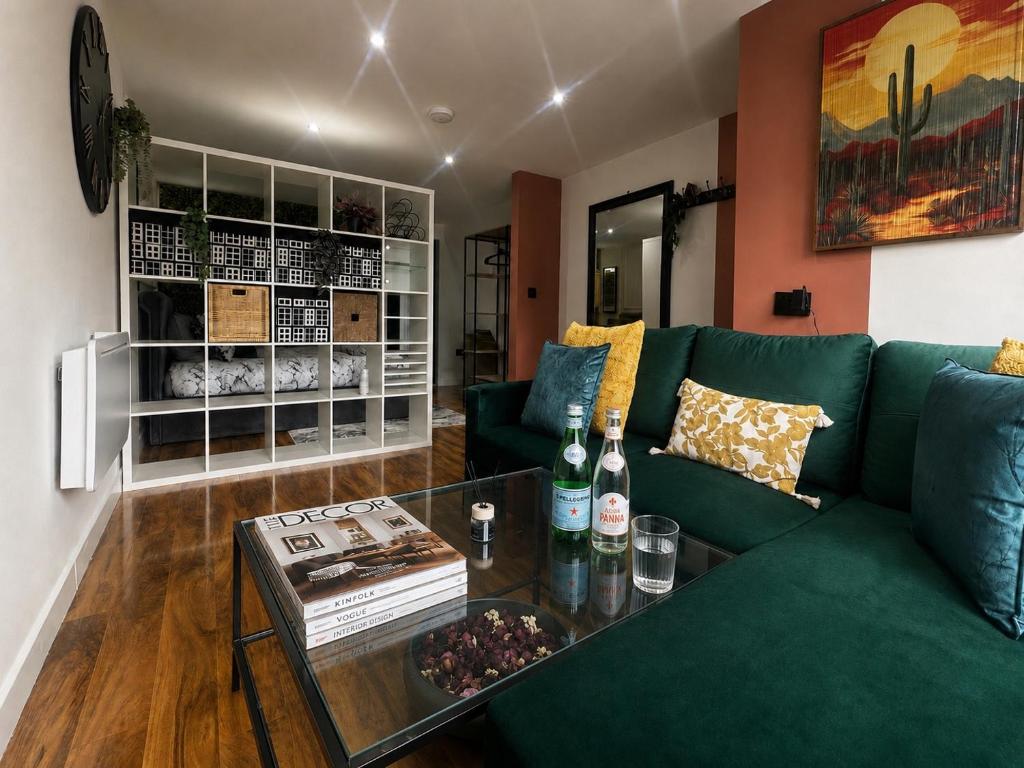 a living room with a green couch and a table at Stylish 1-Bed Apartment in Chester with Parking & Full Kitchen in Chester