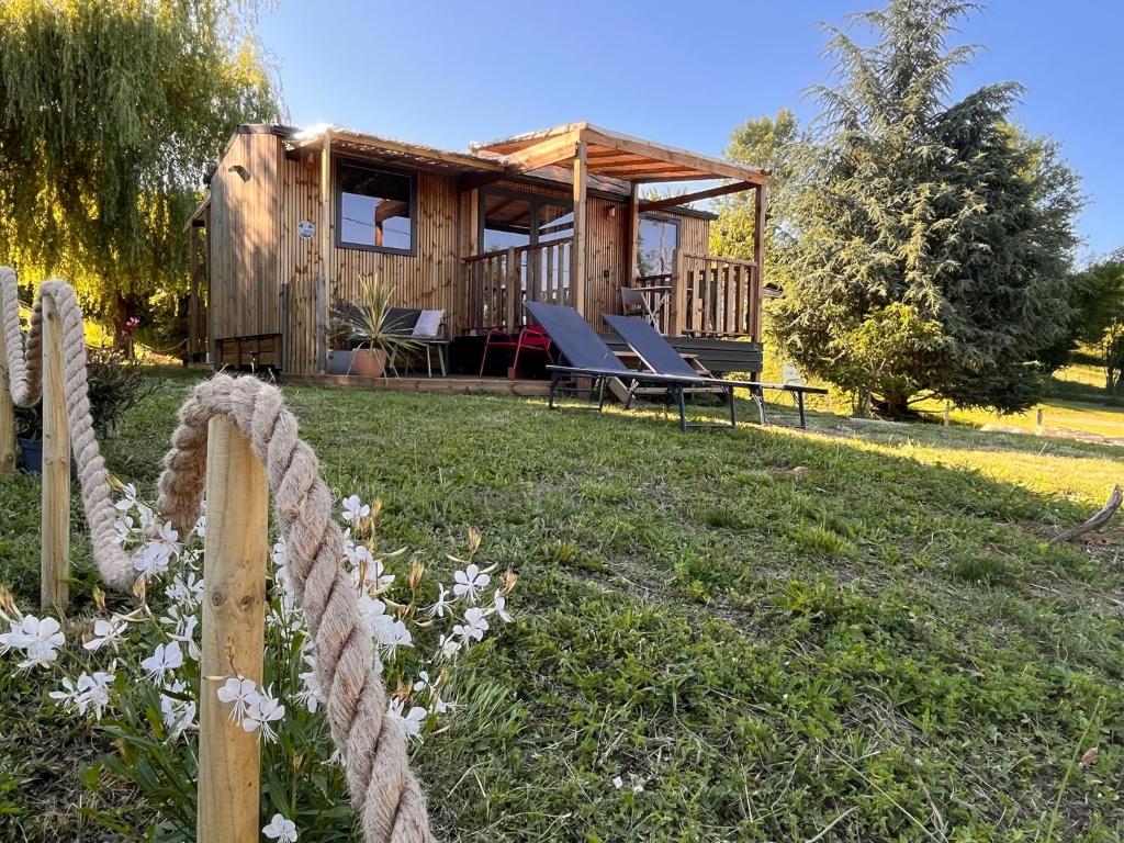 a log cabin with lounge chairs in the yard at O'BARA Lodge - Tiny House - Jardin et climatisation in Druillat