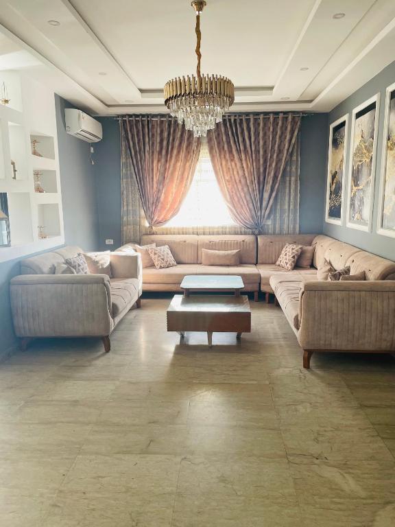 a living room with couches and a chandelier at Lengliz in Kelibia
