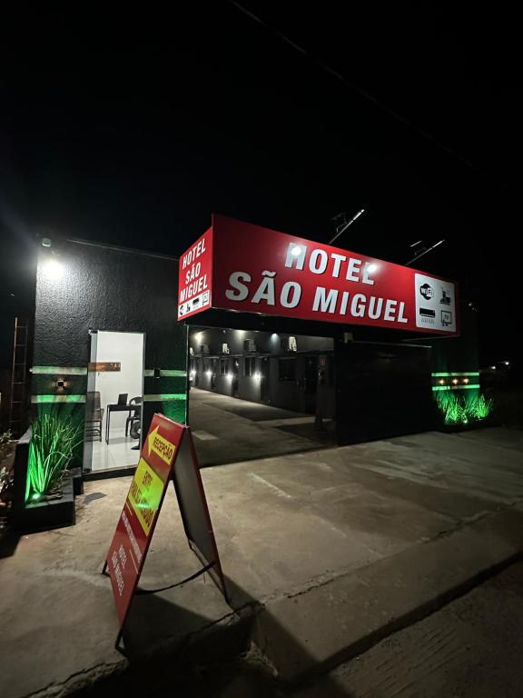 a motel sao miguel sign in a parking lot at night at Hotel São Miguel in Posse