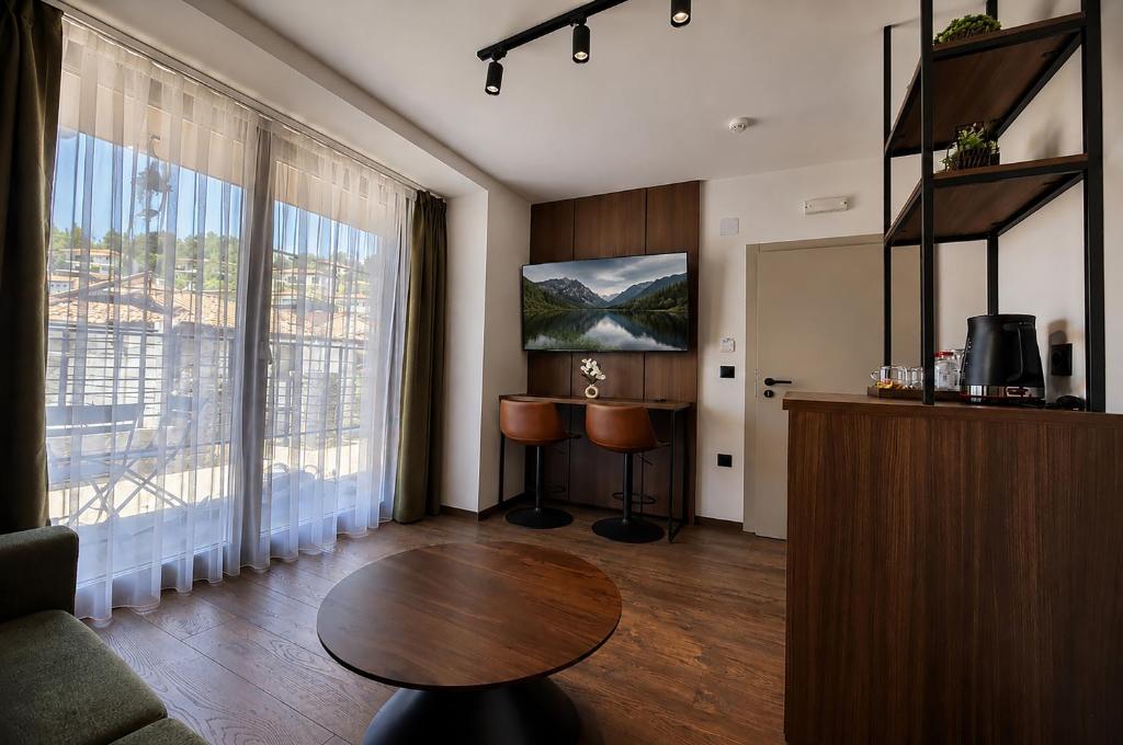 a living room with a table and some windows at NOCE Luxury Apartments in Ohrid