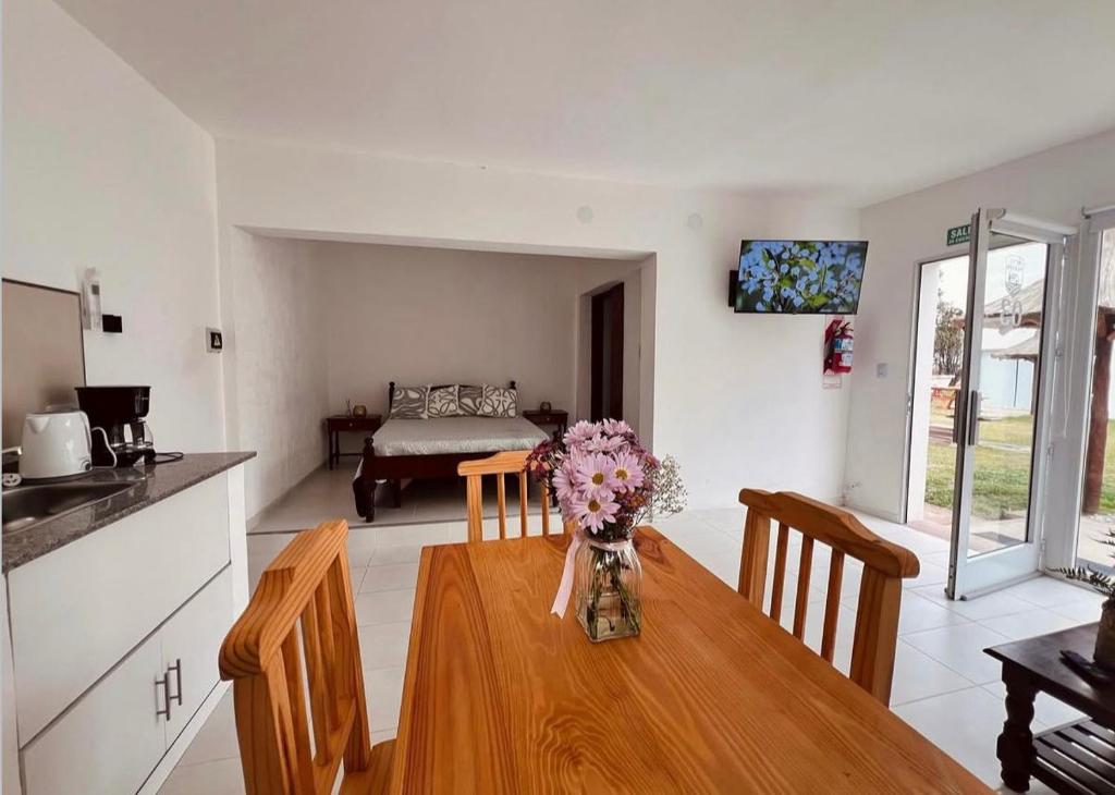 a kitchen and dining room with a table with flowers on it at Hotel De Campo Firmat in Firmat