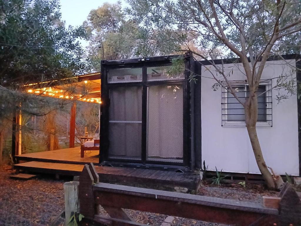 a tiny house with a porch and a deck at Tu lugar de relax a 2 cuadras de la playa Se reserva con seña in Guazuvira