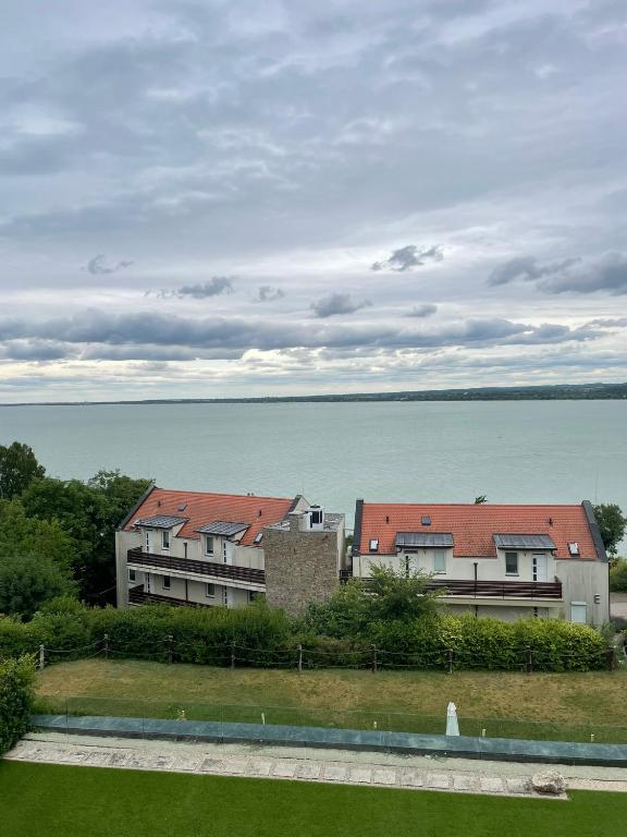two buildings in front of a large body of water at T8 Sunset Tihany in Tihany