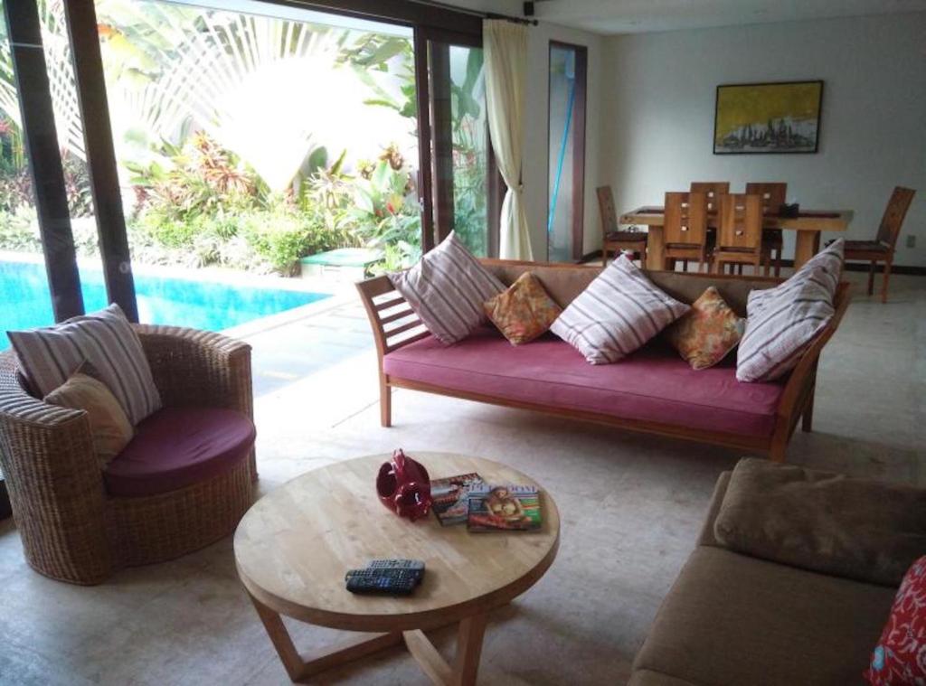 sala de estar con sofá púrpura y mesa en Villa Kejora 10, en Sanur