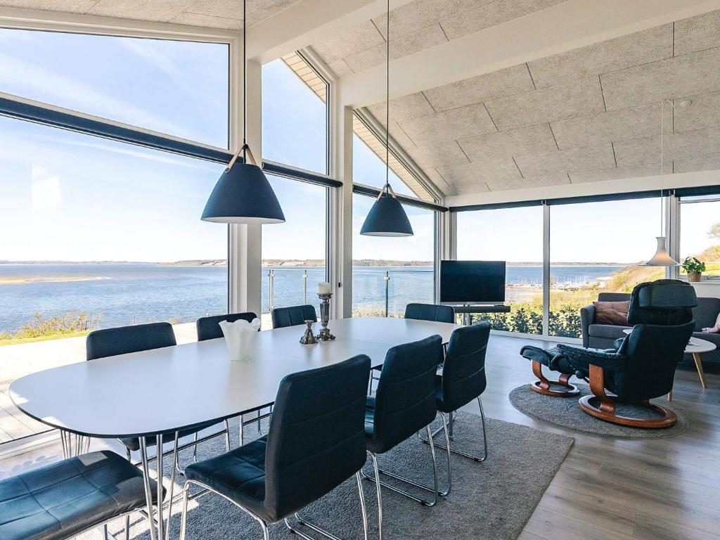 a dining room with a table and chairs and windows at 5 star holiday home in Løgstrup in Løgstrup