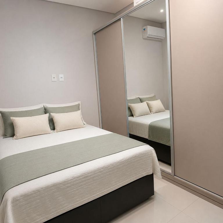 a bedroom with two beds and a large mirror at Anápolis city in Anápolis