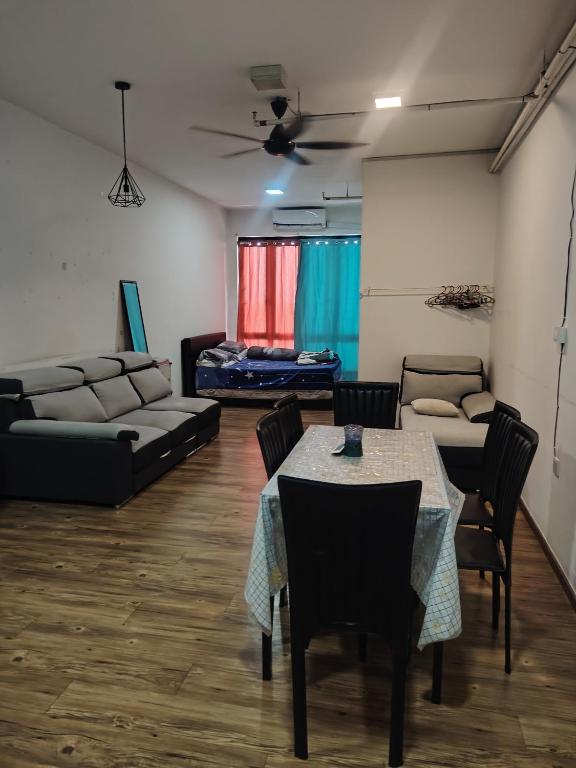 a living room with a couch and a table and chairs at Suria jaya studio condo shah alam in Shah Alam