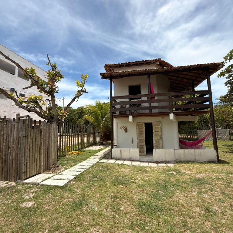 a small white house with a wooden fence at Kcasa13 in Corumbau