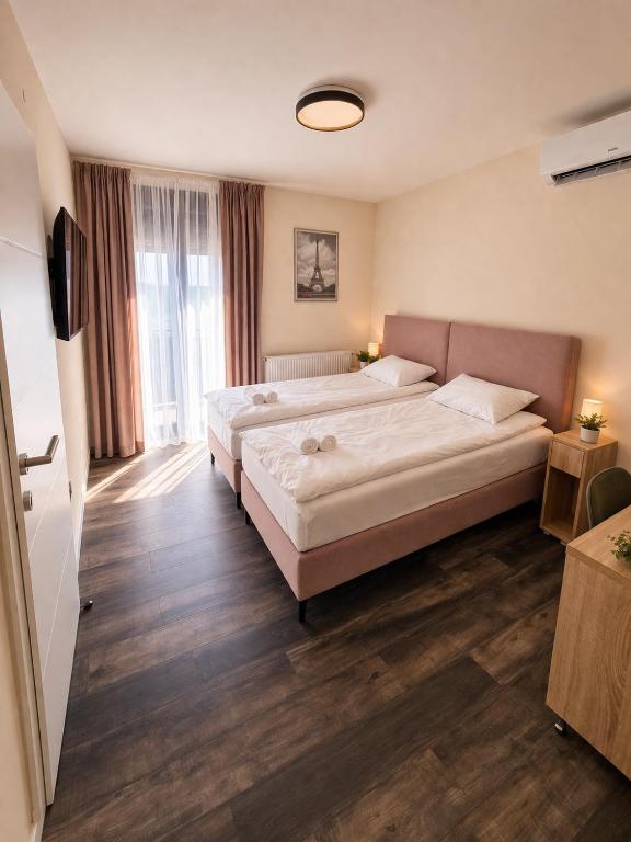 a hotel room with two beds and a television at Apartmani Sjenjak Prestige in Tuzla