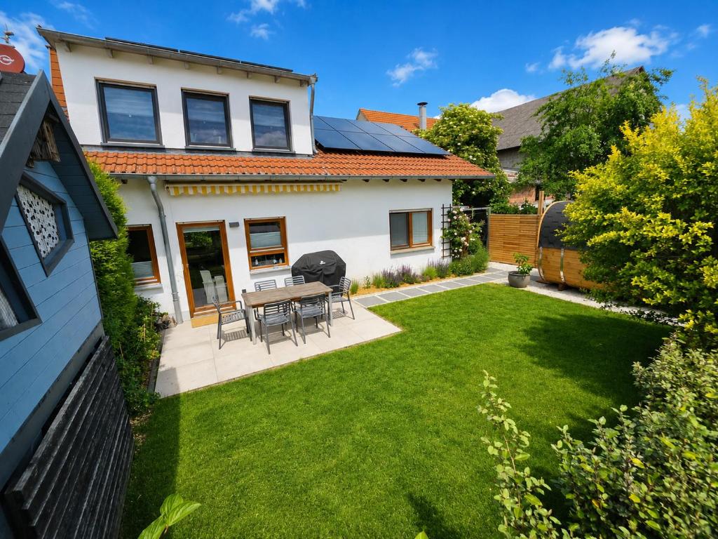 an image of a backyard with a table and chairs at Modernes Ferienhaus mit großer Küche, Terrasse & Garten in Bad Camberg