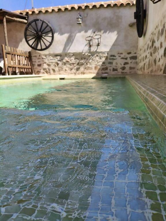 a large pool of water in a building with a wheel at Casa Rural Abuelo Pedro in Cuerva