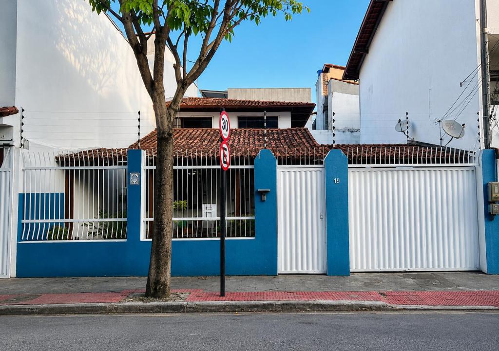a blue and white gate in front of a building at Sossai Hostel in Vitória