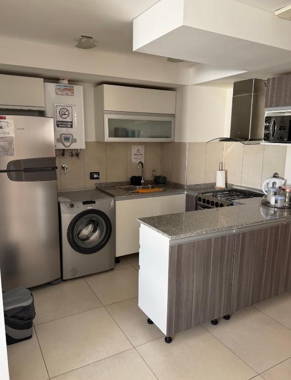 a kitchen with a washing machine and a washer at Aura Residence in Comodoro Rivadavia