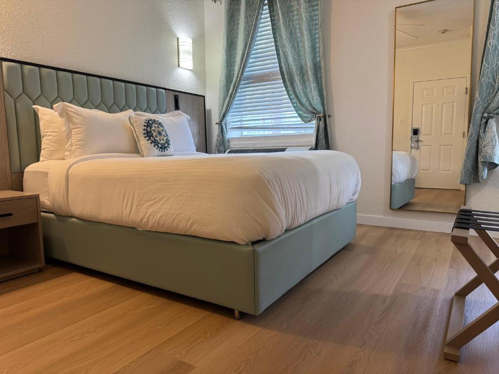 a bedroom with a large bed with a large window at Athens Hotel & Suites in Houston