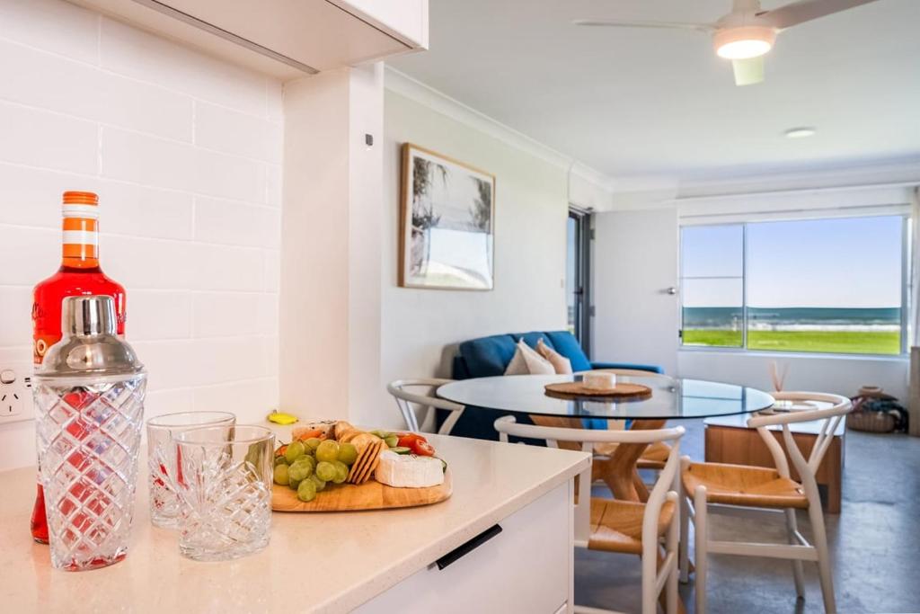 a bottle of wine on a counter in a living room at Absolute Beachfront Apartment 3B in Lennox Head