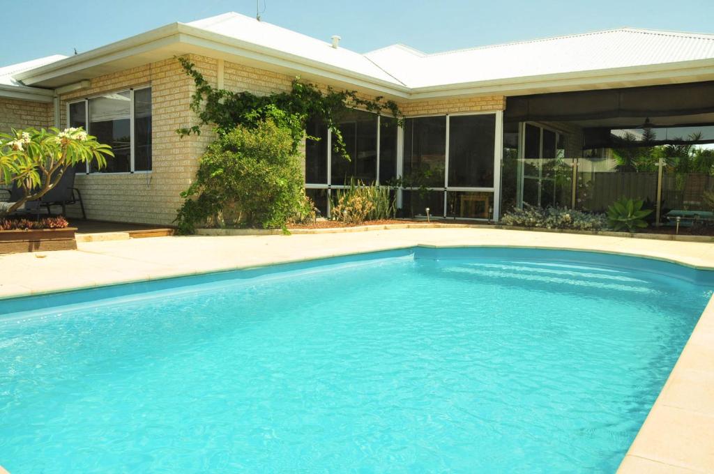 a swimming pool in front of a house at Halls Head Holiday Home in Mandurah