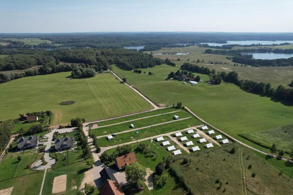 an aerial view of a large field with houses and trees at Camping Szelągówka in Sorkwity