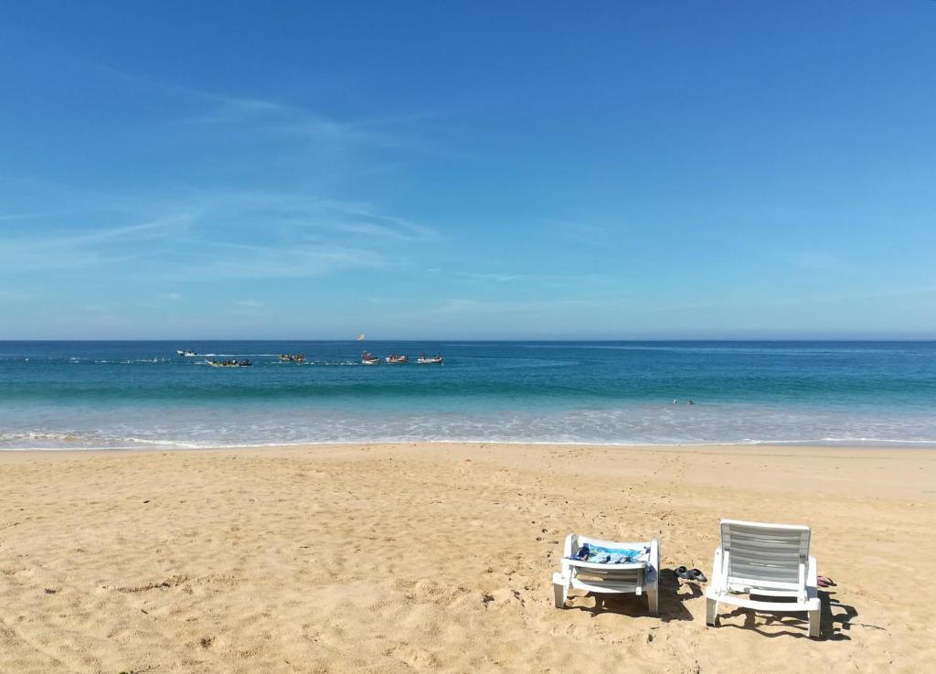 duas cadeiras sentadas numa praia com o oceano em Sunrise Beach Inn em Ambalangoda