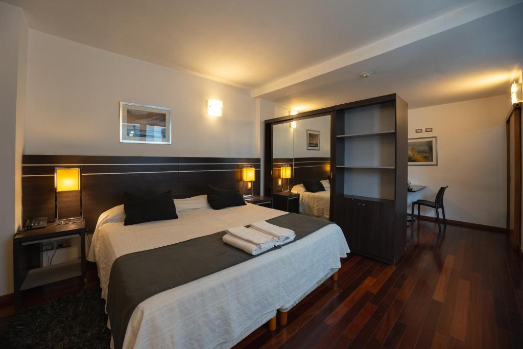 a hotel room with a large bed and a desk at Zoom Apartments Hotel in Córdoba