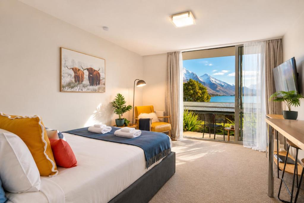 a bedroom with a bed and a large window at Lake & Mountain Views, Close to Shops & Dining in Queenstown