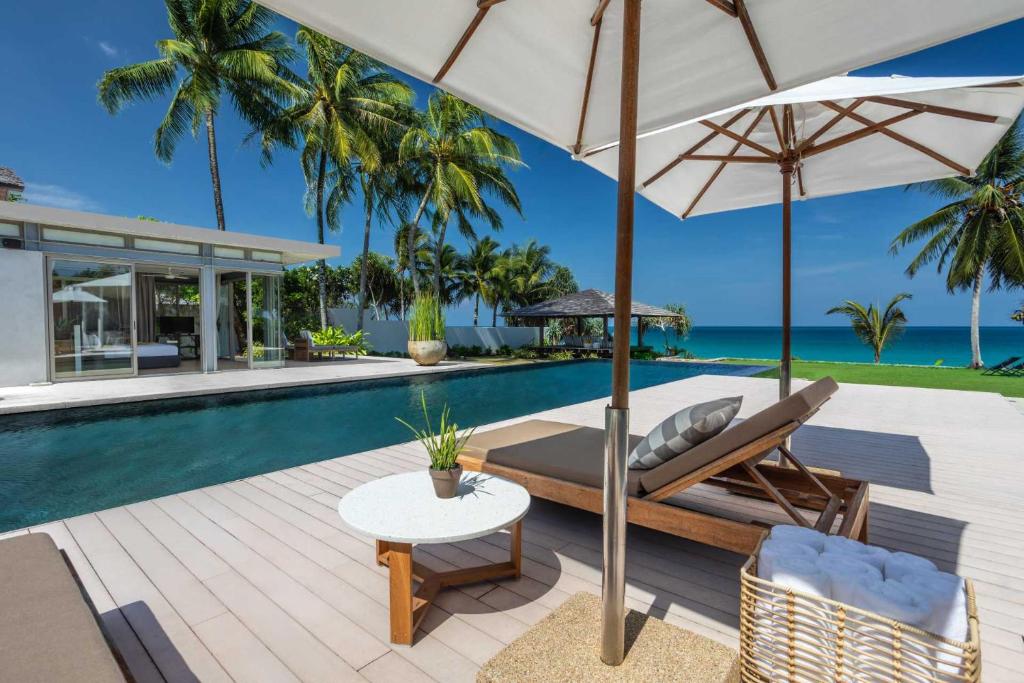 an outdoor patio with a table and an umbrella at Villa Amarelo in Ban Han Pa To