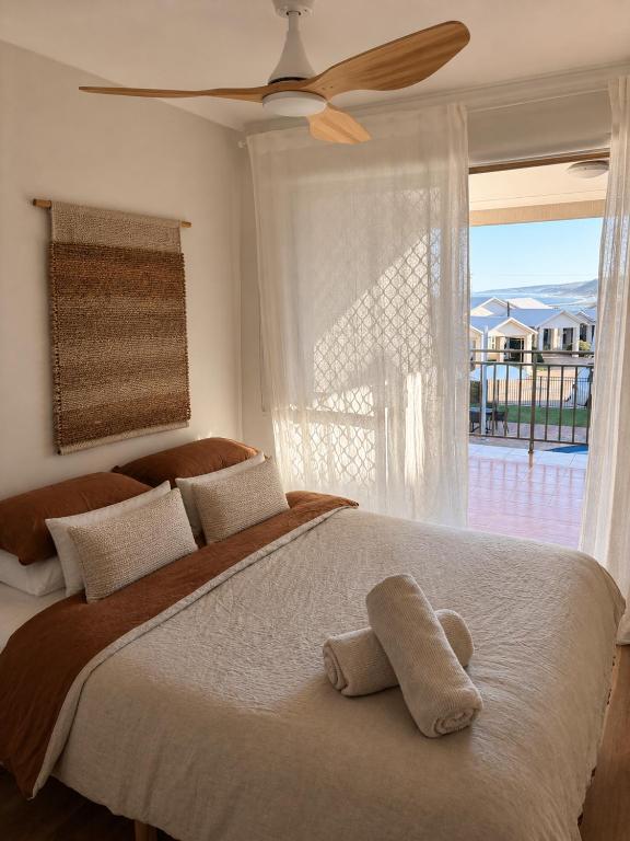 a bedroom with a bed with a fan and a window at Kawa House in Kalbarri
