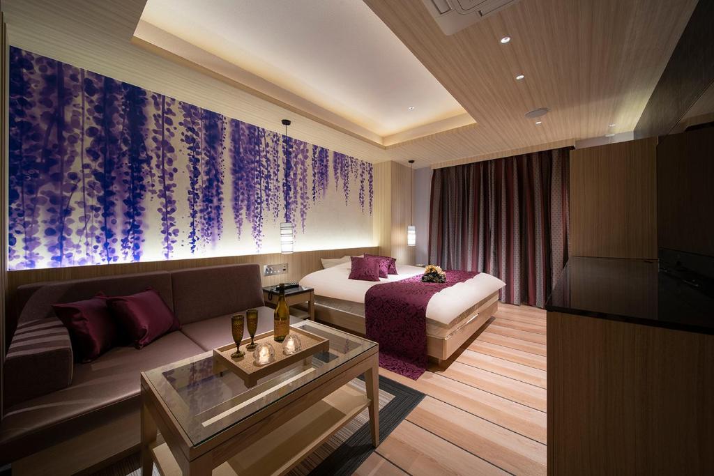 a hotel room with a bed and a couch at ホテル ポルト 男塾ホテルグループ in Himeji